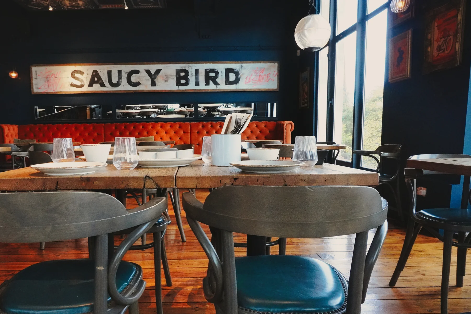 View across restaurant tables towards the Saucy Bird sign